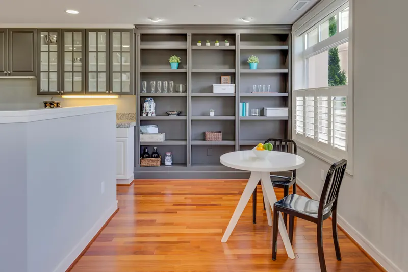 Reference photograph: grey kitchen cabinetry and open shelving above a warm wood floor.