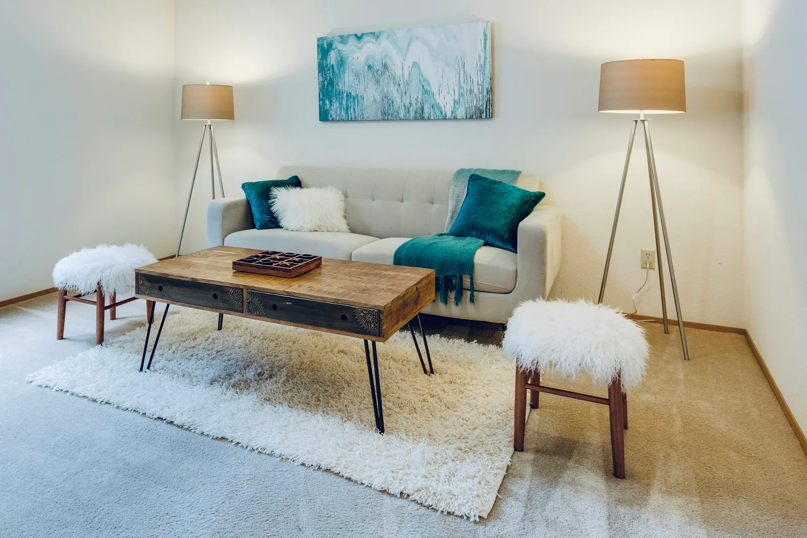Reference photograph: a light living room with a white sofa, turquoise accents and a wood coffee table.
